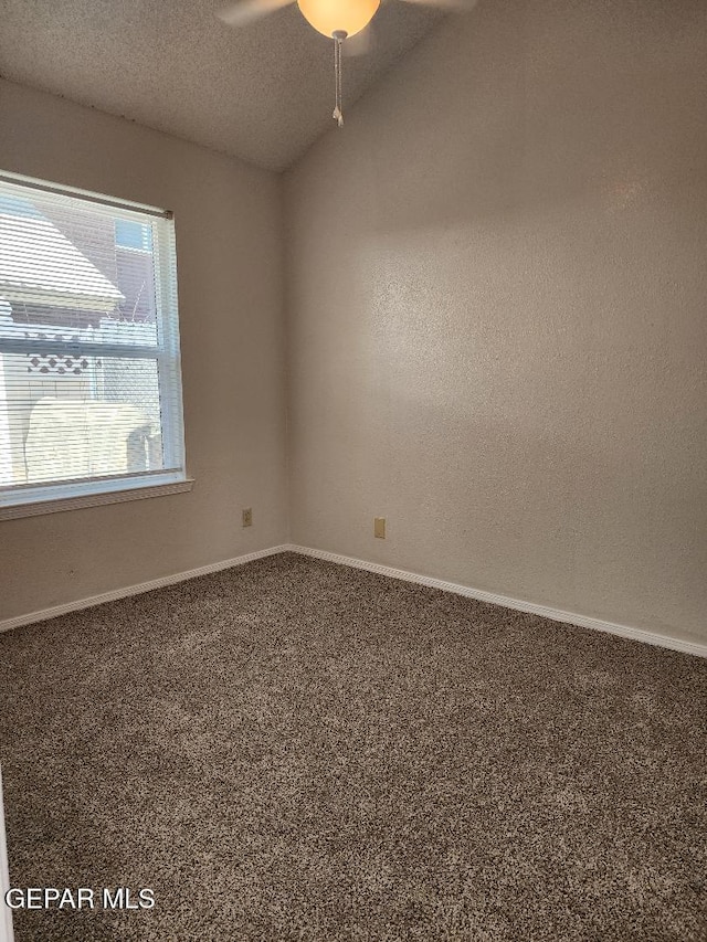 carpeted spare room featuring ceiling fan, baseboards, and a textured ceiling