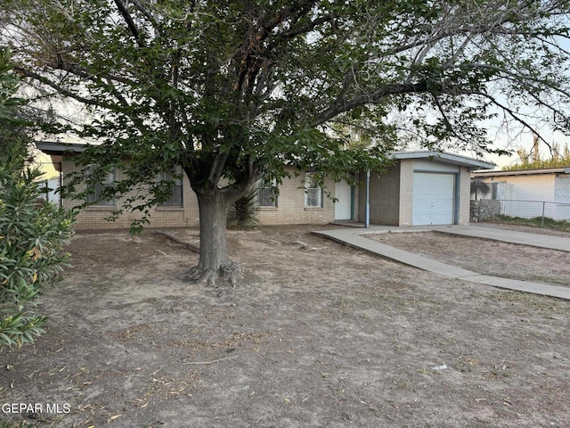 305 Corvena Way, El Paso, TX 79922 - view of property hidden behind natural elements featuring brick siding, driveway, fence, and a garage