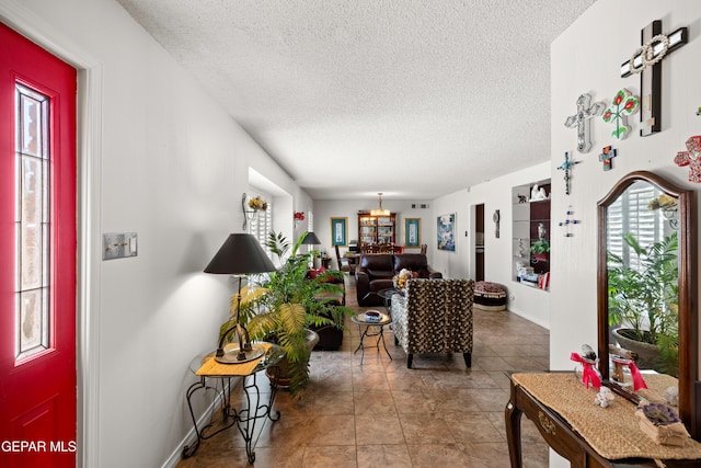 5051 Montoya Dr, El Paso, TX 79922 - tiled living area featuring a textured ceiling, a chandelier, and baseboards