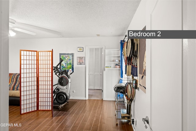 5051 Montoya Dr, El Paso, TX 79922 - workout area featuring a textured ceiling, wood finished floors, ceiling fan, and baseboards