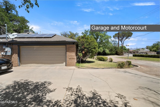 5051 Montoya Dr, El Paso, TX 79922 - view of home's exterior featuring brick siding, driveway, solar panels, and a garage