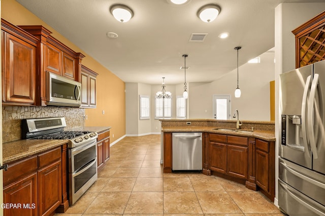 14117 Rainbow Point Dr, El Paso, TX 79938 - kitchen featuring appliances with stainless steel finishes, tasteful backsplash, a chandelier, a peninsula, and hanging light fixtures