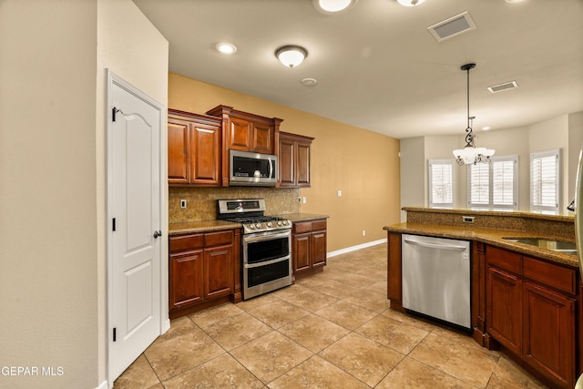 14117 Rainbow Point Dr, El Paso, TX 79938 - kitchen featuring appliances with stainless steel finishes, backsplash, a chandelier, decorative light fixtures, and light tile patterned floors