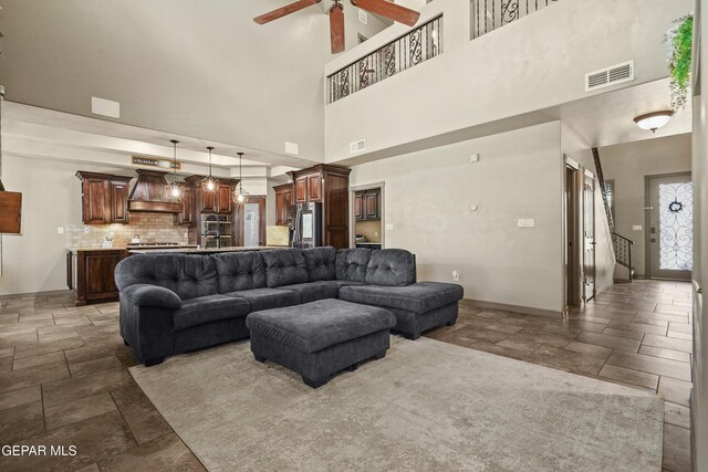 3089 Snowy Point Dr, El Paso, TX 79938 - living area with stone tile flooring, a ceiling fan, a towering ceiling, and baseboards