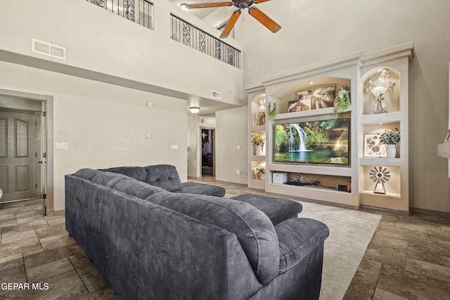3089 Snowy Point Dr, El Paso, TX 79938 - living area featuring stone tile floors, a ceiling fan, a high ceiling, and baseboards