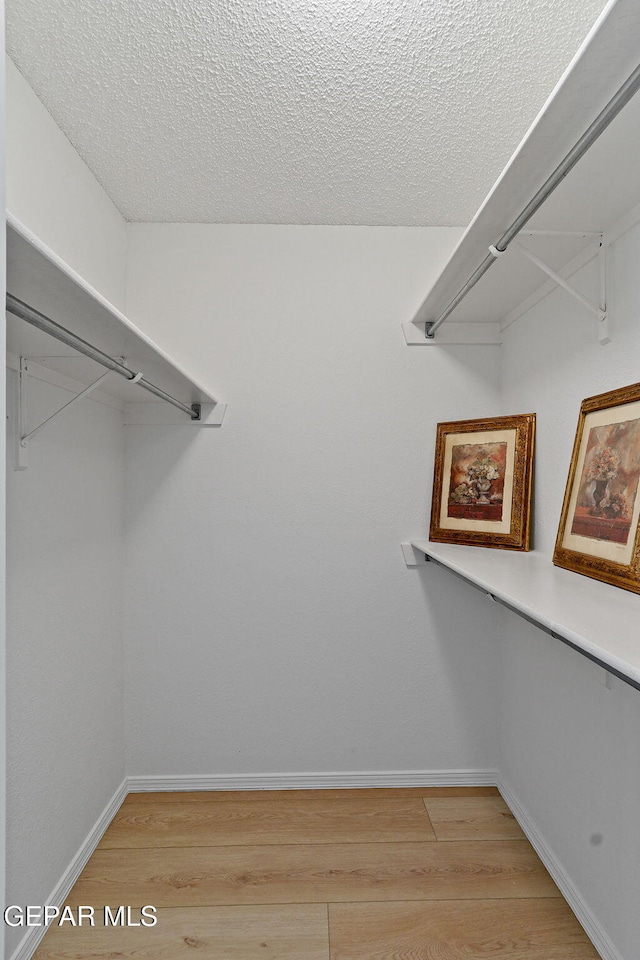 6140 Los Robles Dr, El Paso, TX 79912 - spacious closet featuring light wood-type flooring