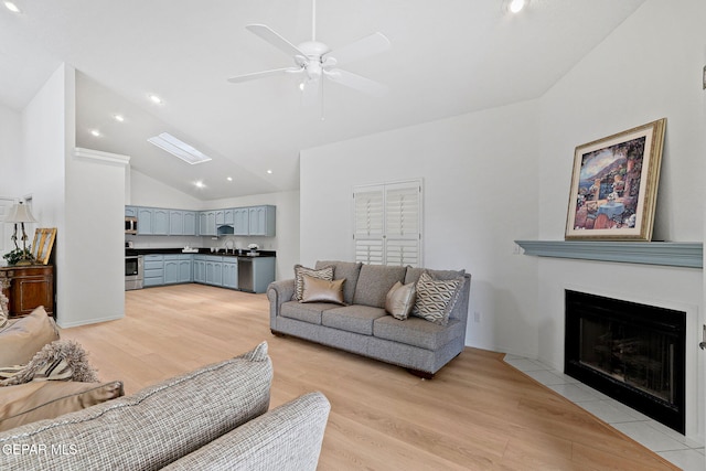 6140 Los Robles Dr, El Paso, TX 79912 - living area with light wood-style flooring, vaulted ceiling, ceiling fan, a fireplace with flush hearth, and recessed lighting