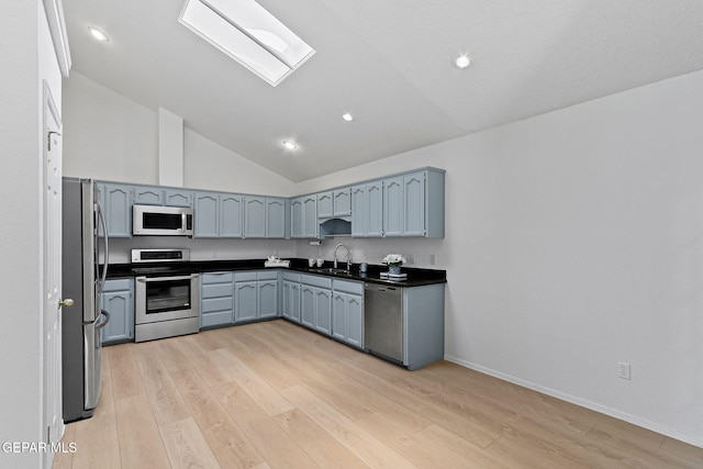 6140 Los Robles Dr, El Paso, TX 79912 - kitchen with appliances with stainless steel finishes, dark countertops, light wood-style flooring, a skylight, and recessed lighting