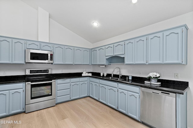 6140 Los Robles Dr, El Paso, TX 79912 - kitchen with stainless steel appliances, lofted ceiling, open shelves, light wood-type flooring, and blue cabinets