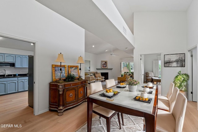 6140 Los Robles Dr, El Paso, TX 79912 - dining space featuring light wood finished floors, a ceiling fan, recessed lighting, and a towering ceiling
