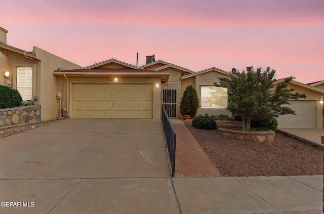 6140 Los Robles Dr, El Paso, TX 79912 - view of front of home featuring stucco siding, driveway, and an attached garage
