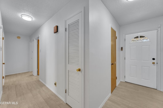 10125 Castletown Dr, El Paso, TX 79925 - hallway featuring a textured ceiling, light wood-style flooring, and baseboards