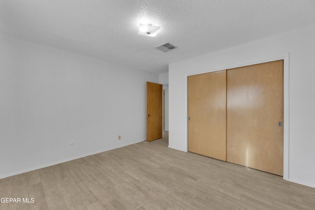 10125 Castletown Dr, El Paso, TX 79925 - unfurnished bedroom featuring light wood finished floors, a textured ceiling, a closet, and baseboards