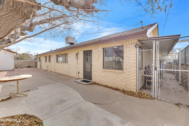 10125 Castletown Dr, El Paso, TX 79925 - back of property with brick siding, fence, a gate, a patio area, and a shingled roof