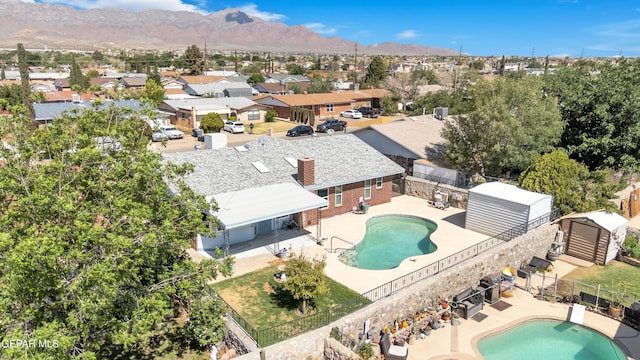 aerial view of residential area with a pool area and a mountain backdrop