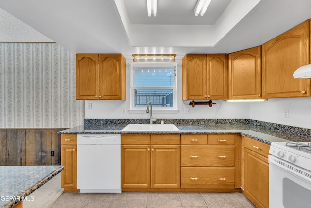 kitchen with white appliances, a sink, wallpapered walls, and brown cabinetry