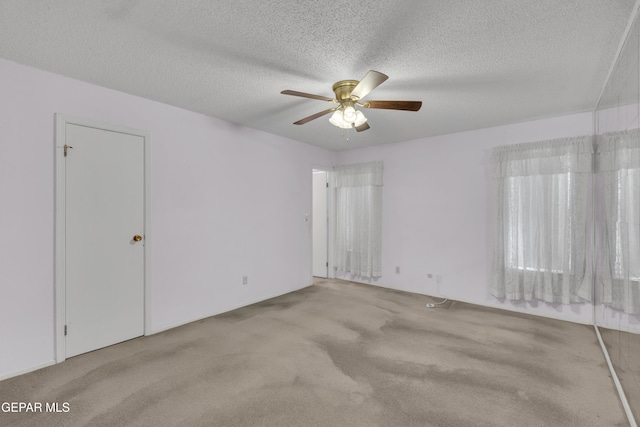 carpeted spare room featuring a ceiling fan and a textured ceiling