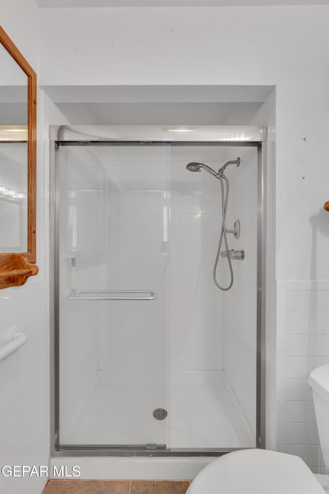 bathroom with toilet and a shower stall