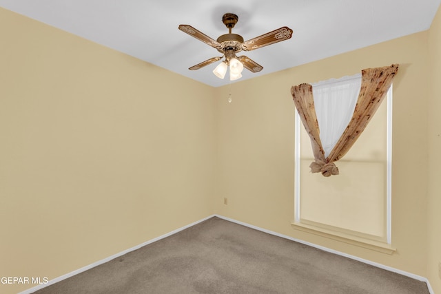 unfurnished room with baseboards, carpet flooring, and a ceiling fan