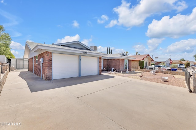 single story home with brick siding, a garage, and fence