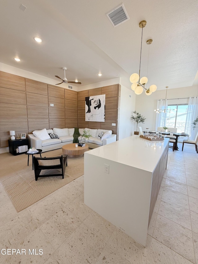 15101 Steer Dr, El Paso, TX 79938 - kitchen with a spacious island, recessed lighting, brown cabinetry, ceiling fan, and pendant lighting
