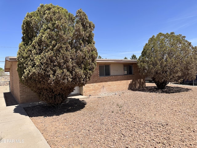 view of front of house with brick siding and fence