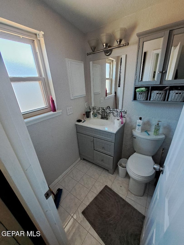 bathroom with toilet, tile patterned floors, and vanity