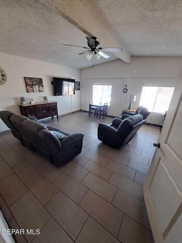 tiled living area featuring ceiling fan, a textured ceiling, and vaulted ceiling