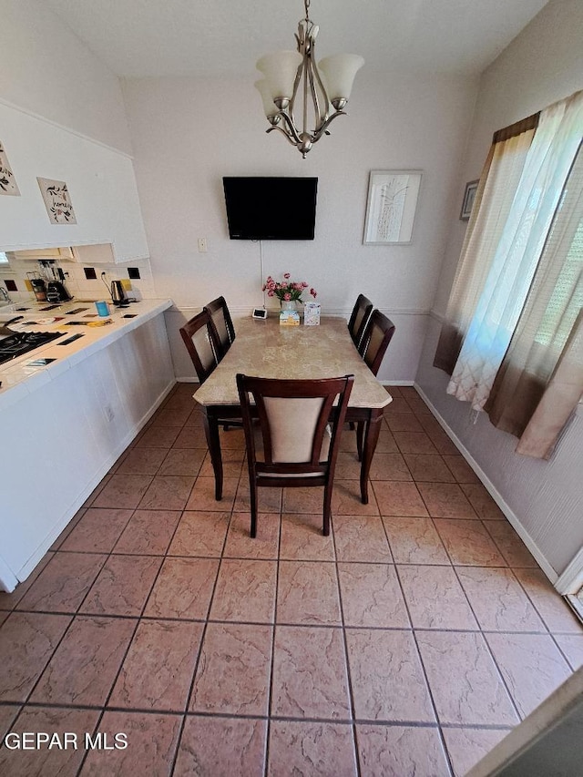 dining area with a chandelier and light tile patterned flooring