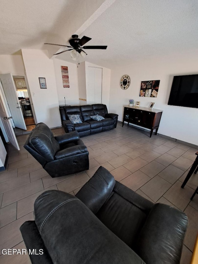 living room featuring ceiling fan, tile patterned flooring, and a textured ceiling