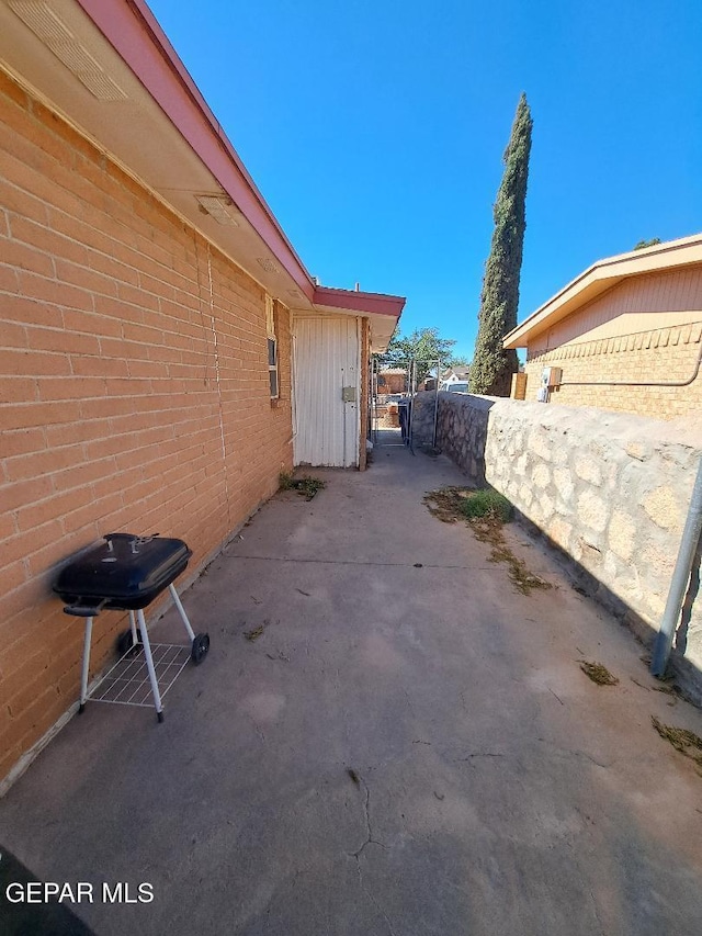 view of property exterior with fence and a patio area