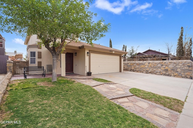 view of front facade featuring driveway, stucco siding, an attached garage, and a gate