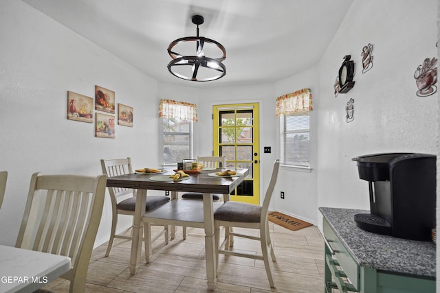 dining space with a chandelier, light wood-type flooring, and baseboards