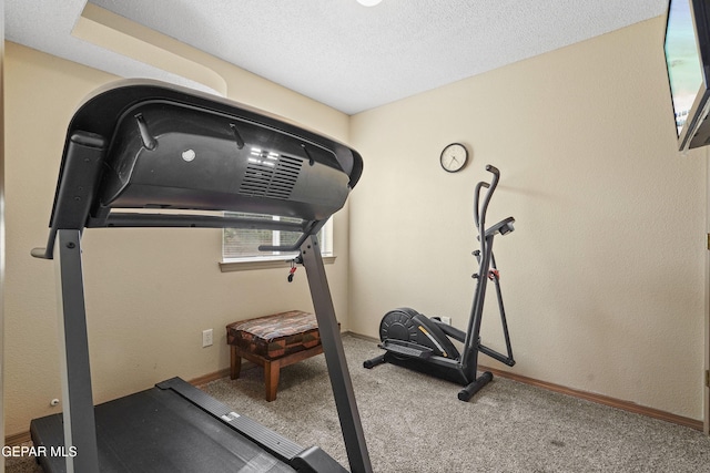 workout room featuring carpet floors, baseboards, and a textured ceiling