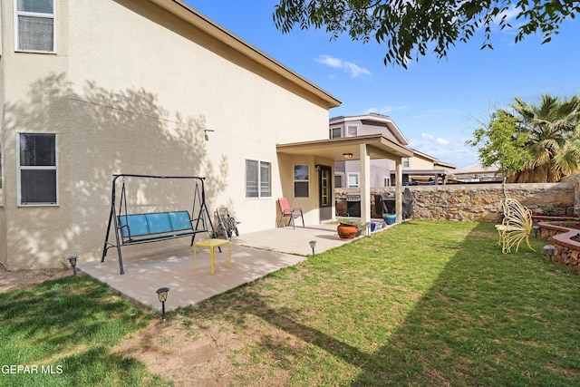 rear view of house with stucco siding and a patio