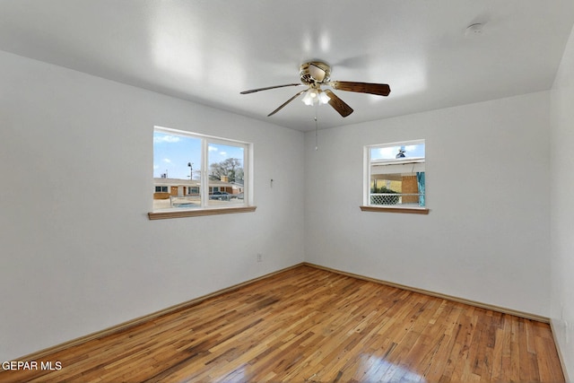 unfurnished room with ceiling fan, hardwood / wood-style floors, a smoke detector, and baseboards