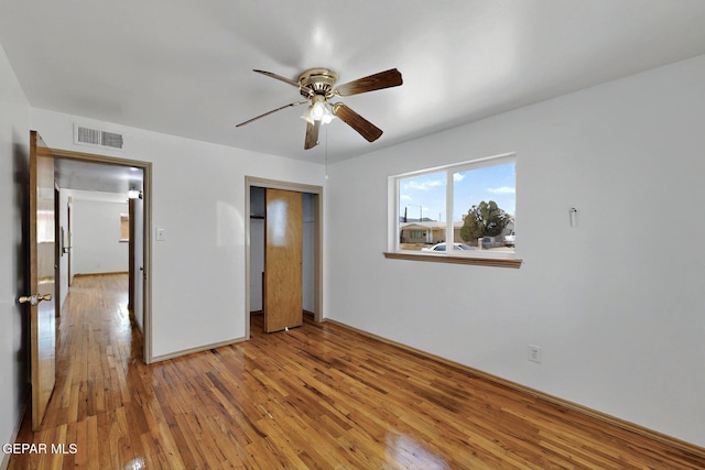 unfurnished bedroom featuring wood-type flooring, a closet, a ceiling fan, and baseboards