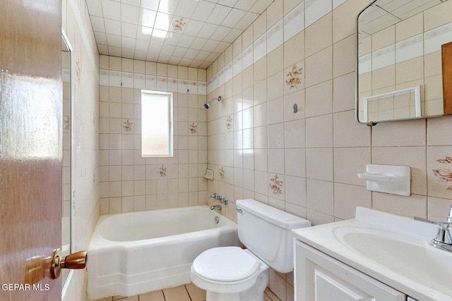 bathroom featuring tile walls, toilet, bathing tub / shower combination, tile patterned flooring, and vanity