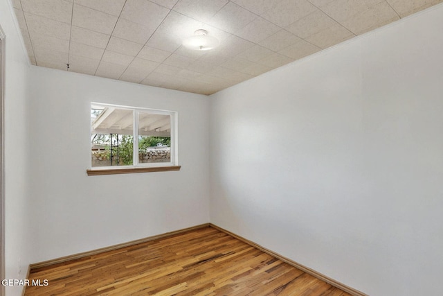 unfurnished room featuring wood finished floors and baseboards