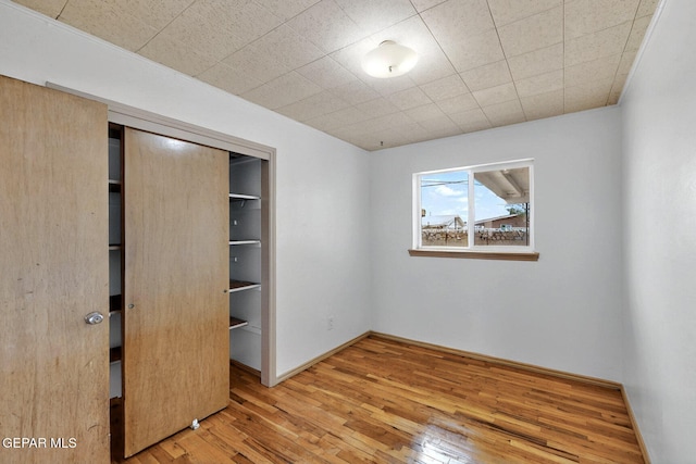 unfurnished bedroom with wood-type flooring and a closet