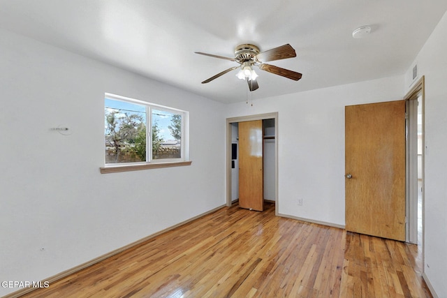 unfurnished bedroom featuring hardwood / wood-style floors, a closet, ceiling fan, and baseboards