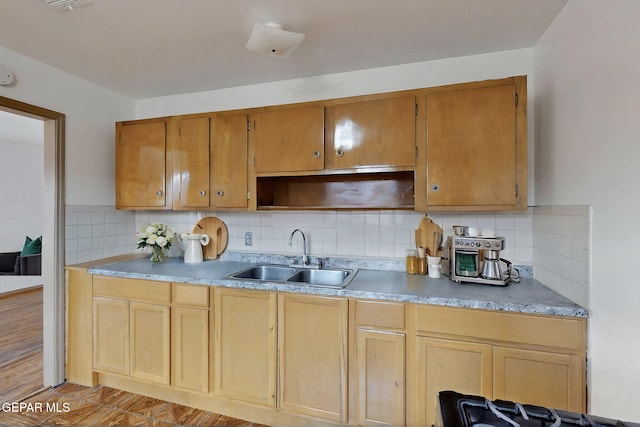 kitchen with a sink, tasteful backsplash, open shelves, and light wood-style flooring