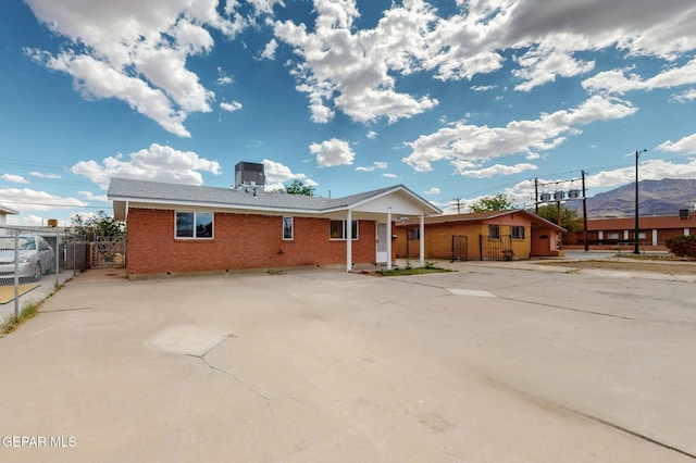 rear view of property with fence, brick siding, a mountain view, a porch, and crawl space
