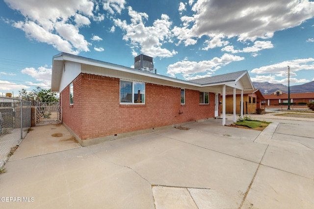 back of house with brick siding, fence, and crawl space