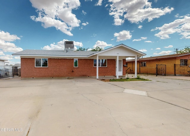 back of house featuring brick siding, fence, and cooling unit