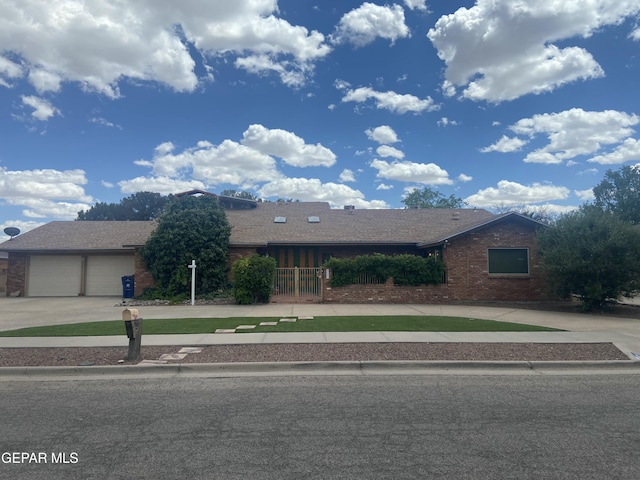 ranch-style house with driveway, brick siding, and an attached garage