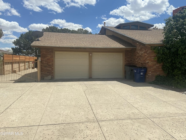 garage with driveway and fence