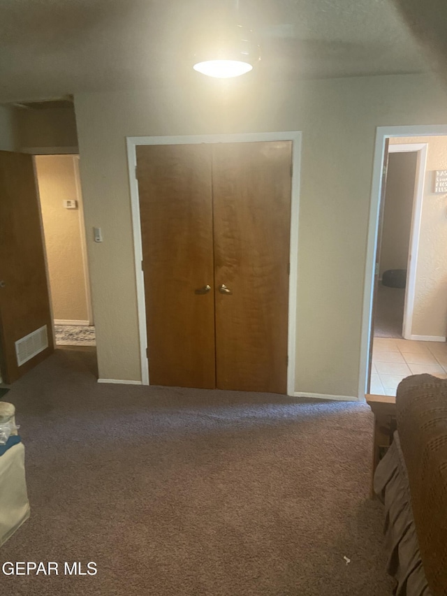 bedroom featuring a closet, baseboards, and light carpet