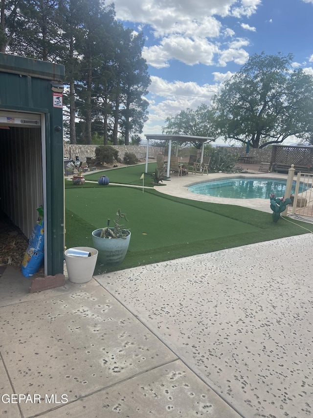 view of community with an area to practice putting, a swimming pool, fence, and a patio