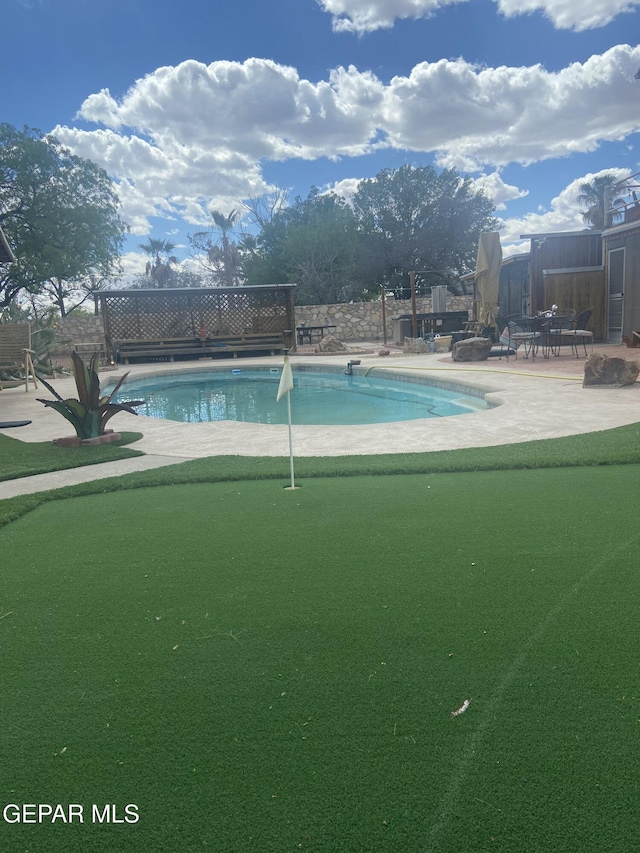 outdoor pool featuring a putting area and a patio area